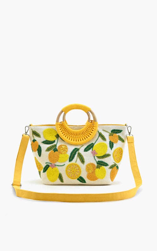 Embroidered handbag with lemons, oranges, and green leaves, featuring a round woven handle and yellow shoulder strap.