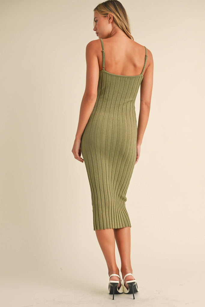 Woman wearing a sage green ribbed midi dress with spaghetti straps and front button detailing.
