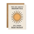 Minimalist birthday card with a sunburst design and bold typography that reads "The Sun Shines Brighter on Your Birthday."