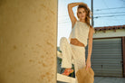 Model wearing cream-colored crochet wide-leg pants with intricate patterns and a high waist.