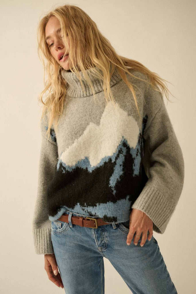 Person wearing a sweater with mountain design against a plain background
