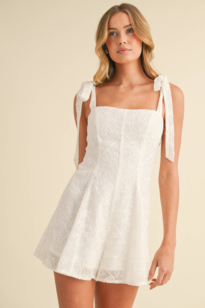 White embroidered romper with shoulder tie straps, worn by model facing front and back