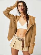 Woman wearing a Sahara Sky Hooded Jacket with a zip-up front, textured waffle knit, and button detailing in blue and brown tones.