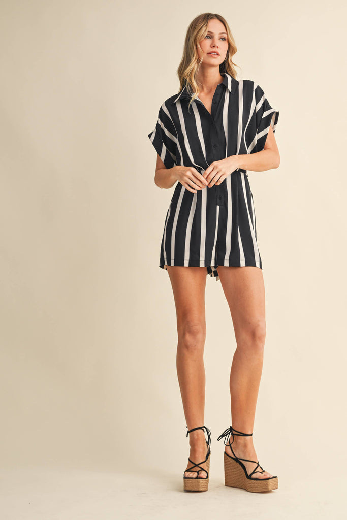 Woman wearing a black and white striped dress on a beige background