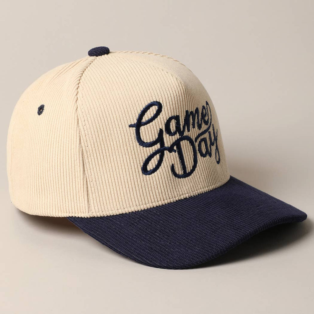 Corduroy trucker baseball cap with "Game Day" embroidered in navy on cream and navy fabric.