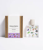 Poom Poom Eau de Parfum bottle with playful illustrations, displayed on an orange and white striped fabric background.