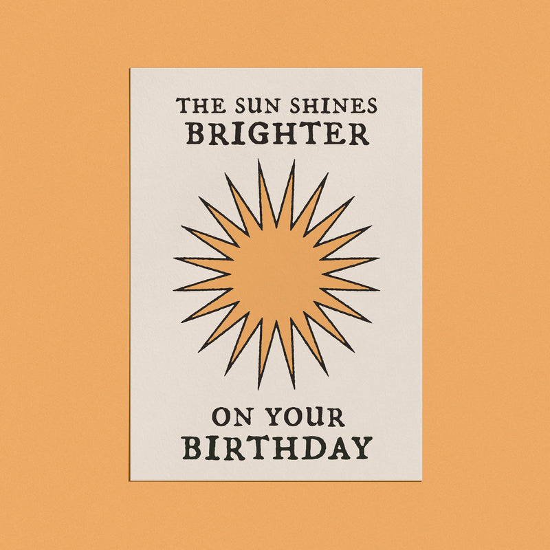 Minimalist birthday card with a sunburst design and bold typography that reads "The Sun Shines Brighter on Your Birthday."