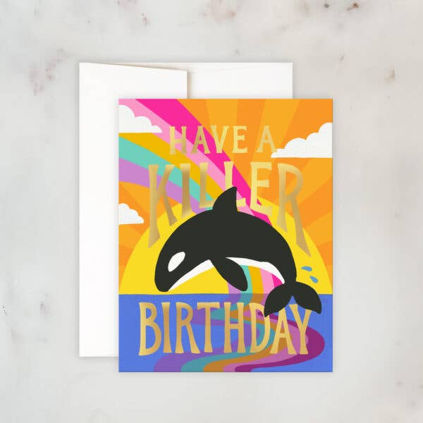 Colorful birthday card with a jumping orca whale, rainbow sky, and text that says “Have a Killer Birthday”.