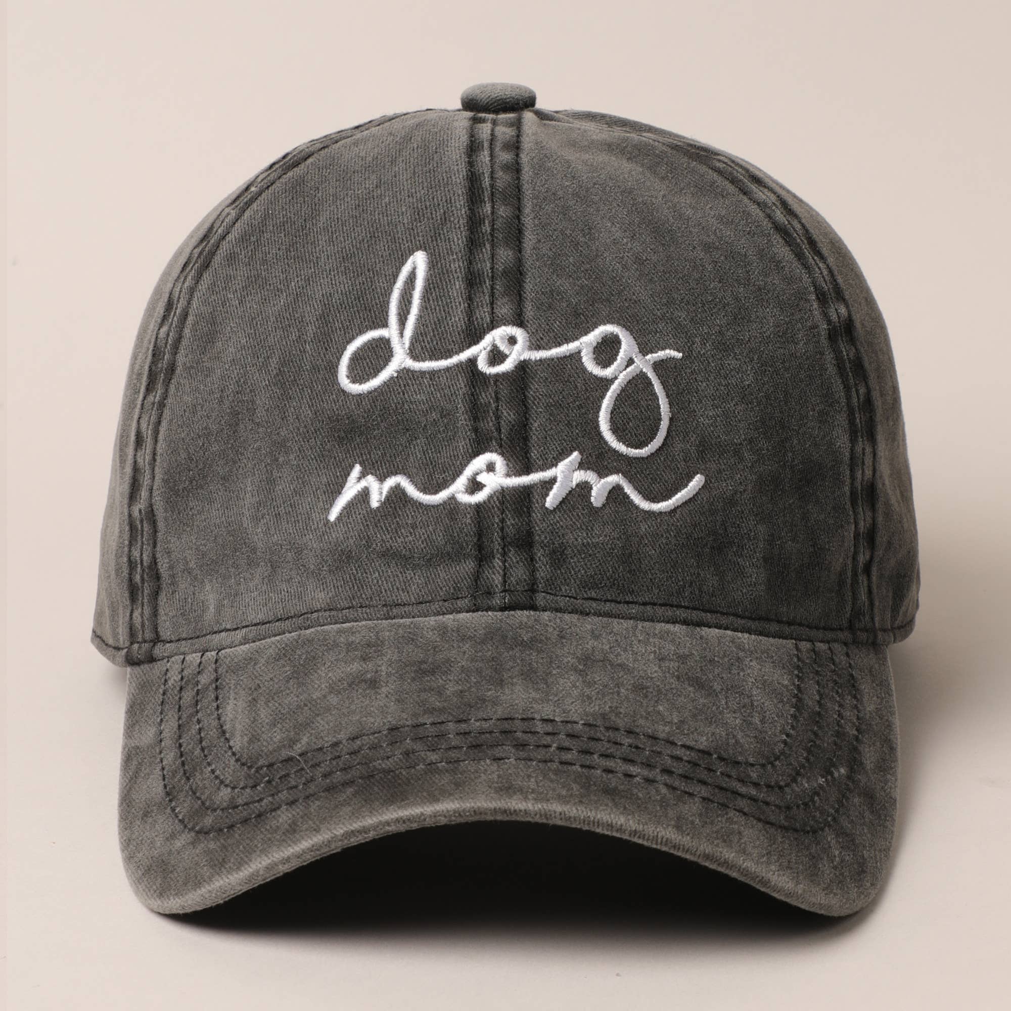 Gray cap with 'dog mom' embroidery on a beige background