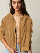 Woman wearing a Sahara Sky Hooded Jacket with a zip-up front, textured waffle knit, and button detailing in blue and brown tones.