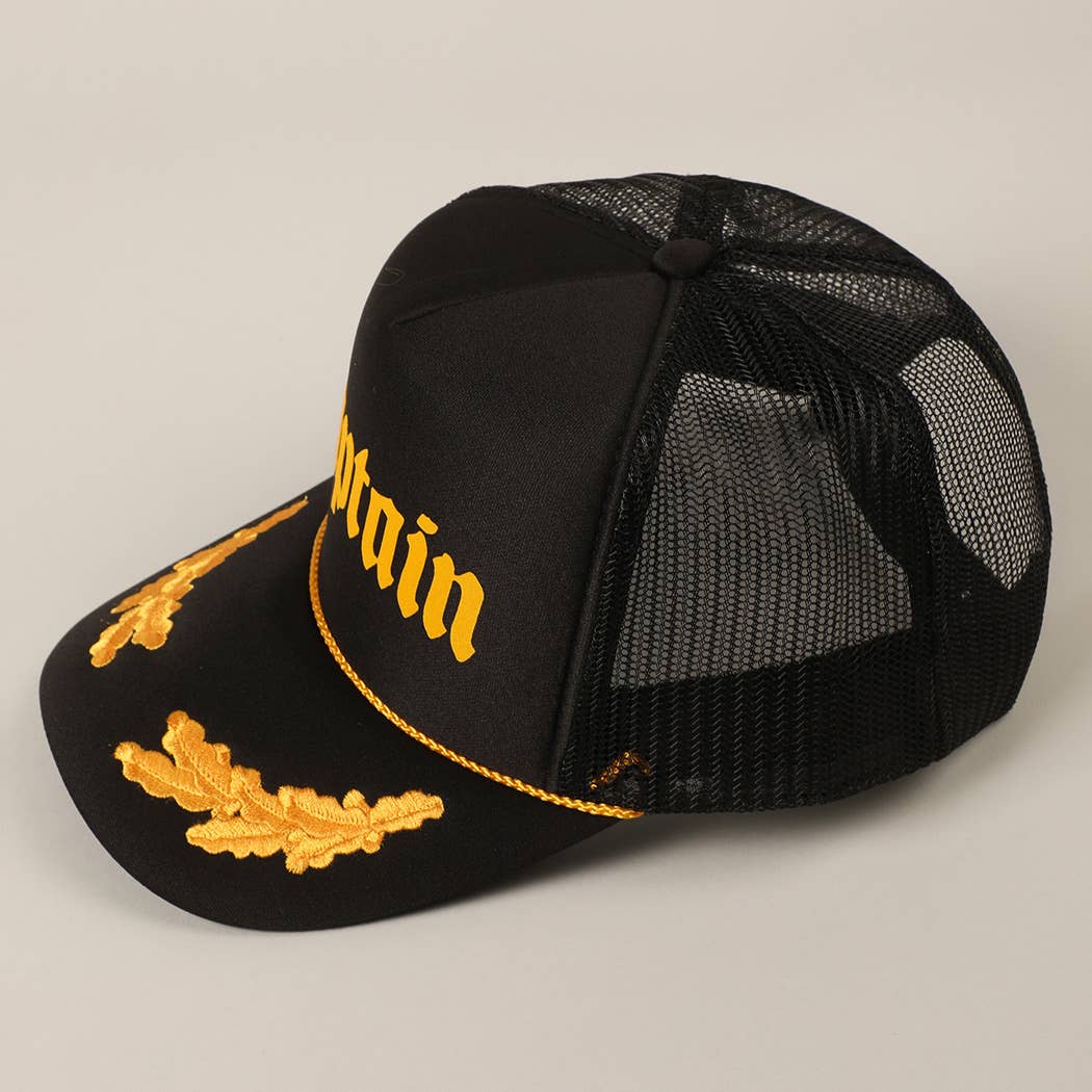 Black cap with gold embroidery on a beige background