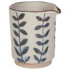 Small ceramic creamer with a speckled glaze and blue leaf pattern, ideal for serving cream, milk, or sauces.