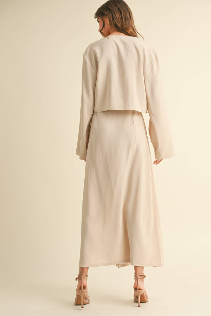 Woman wearing a beige tie-front long sleeve top and matching wrap maxi skirt, styled as a coordinated skirt set.