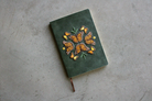 Green notebook with embroidered monarch butterfly design.