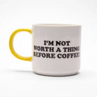 Ceramic mug with the phrase "I'm Not Worth A Thing Before Coffee!" in bold black letters on a white background, paired with a yellow handle.