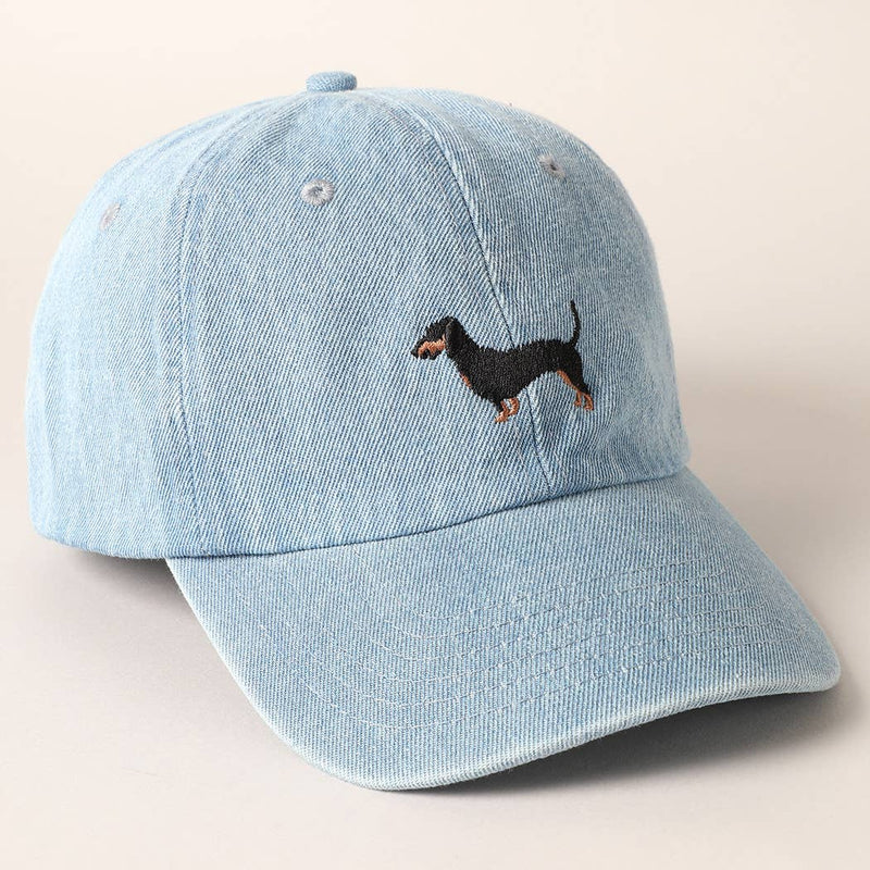 Light blue denim cap with embroidered dachshund on a beige background