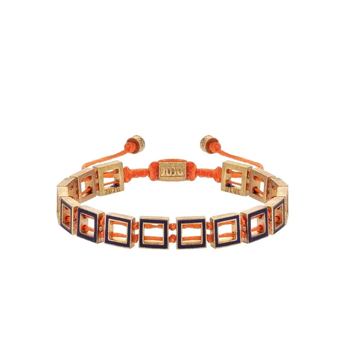 A bronze bracelet with geometric pattern, featuring orange and blue elements, and adjustable ends.