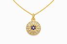 Gold necklace with a circular pendant featuring blue and clear stones on a white background