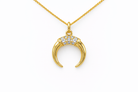 Gold necklace with a crescent moon pendant on a white background