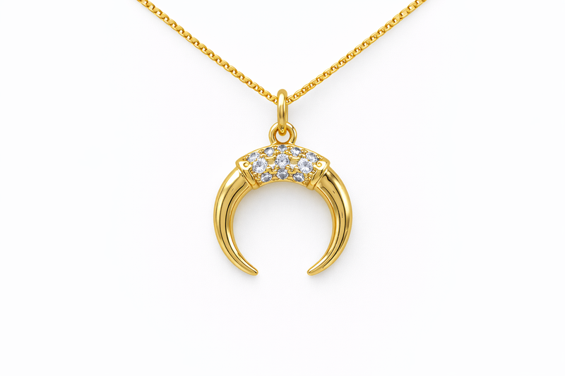 Gold necklace with a crescent moon pendant on a white background