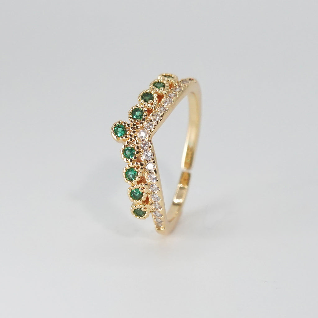 Virginia Ring: Majestic crown-shaped design adorned with shimmering and verdant green stones, epitome of regal elegance.