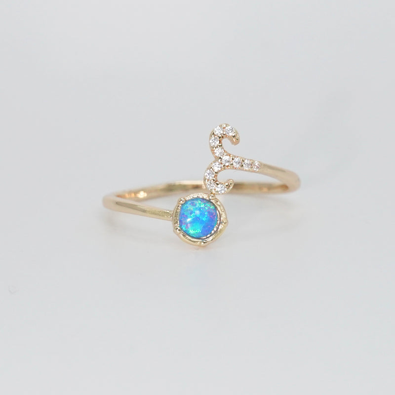 Aries Ring: Ram symbol with shimmering stones surrounding an opal, embodying fiery spirit.