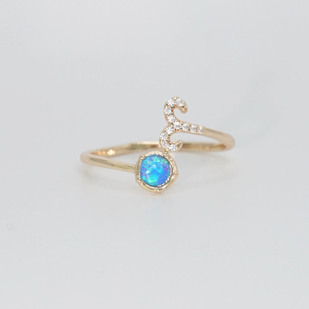 Aries Ring: Ram symbol with shimmering stones surrounding an opal, embodying fiery spirit.