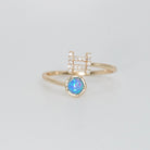 Gemini Ring: Twin symbols with shimmering stones surrounding an opal, symbolizing duality.
