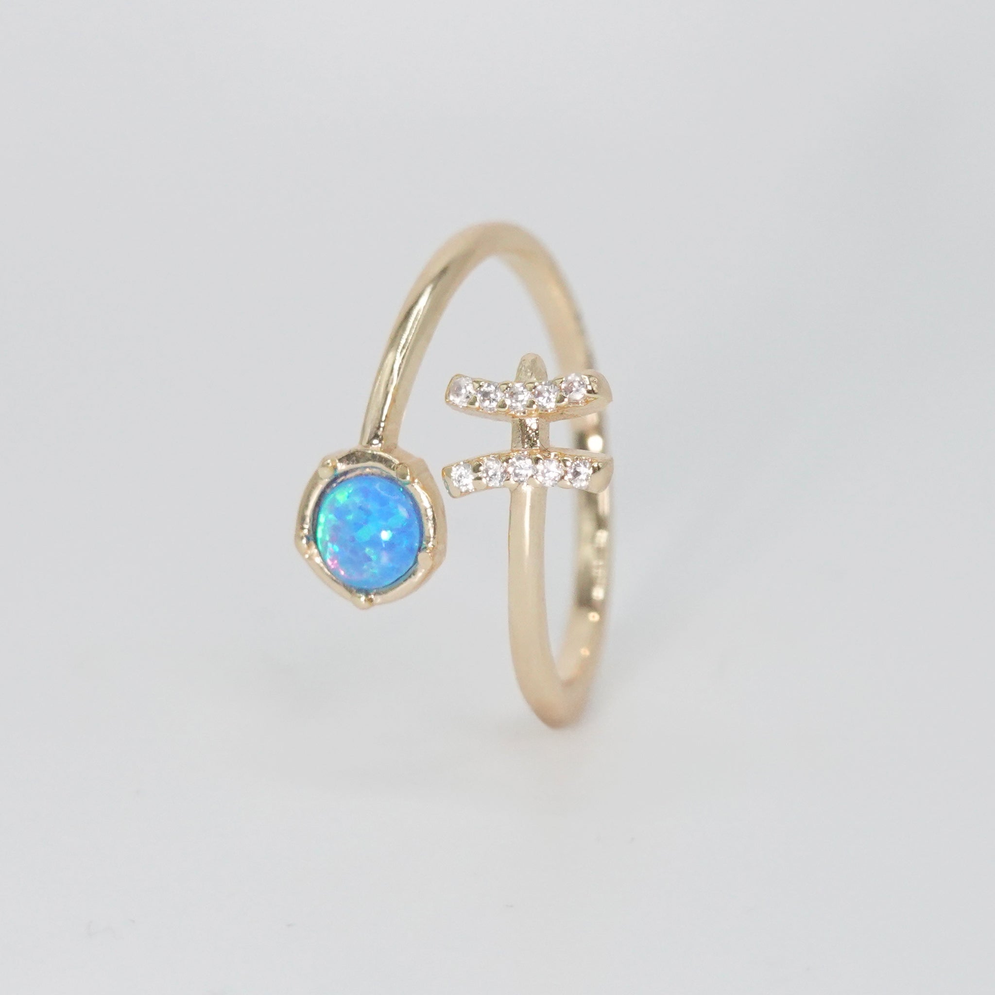 Pisces Ring: Fish symbol with shimmering stones surrounding an opal, epitome of creativity.