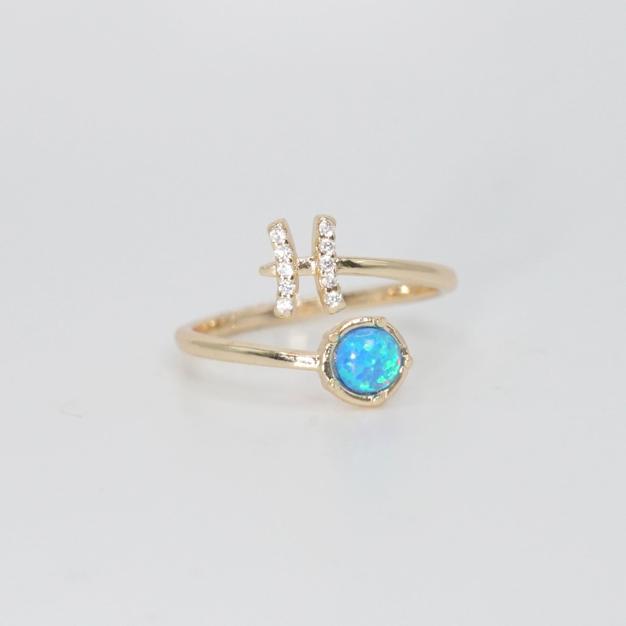 Pisces Ring: Fish symbol with shimmering stones surrounding an opal, epitome of creativity.