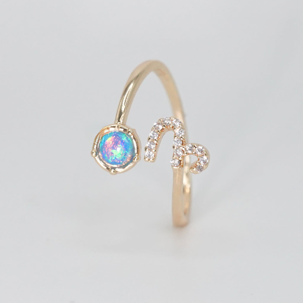 Capricorn Ring: Goat symbol with shimmering stones surrounding an opal, epitome of ambition.