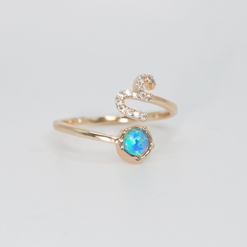 Capricorn Ring: Goat symbol with shimmering stones surrounding an opal, epitome of ambition.