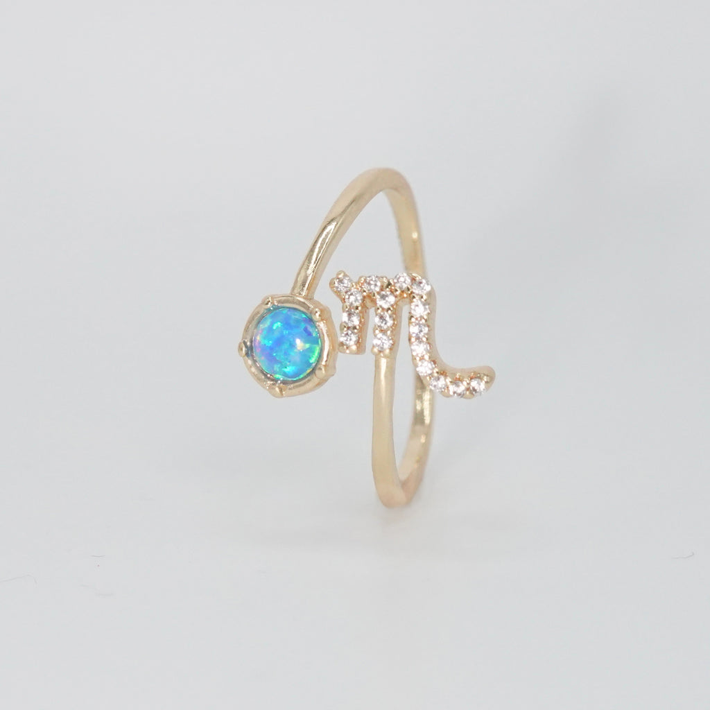 Scorpio Ring: Scorpion symbol with shimmering stones surrounding an opal, epitome of intensity.