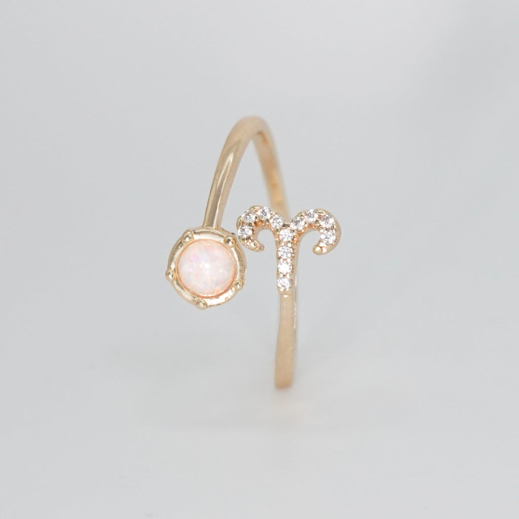 Aries Ring: Ram symbol with shimmering stones surrounding an opal, embodying fiery spirit.