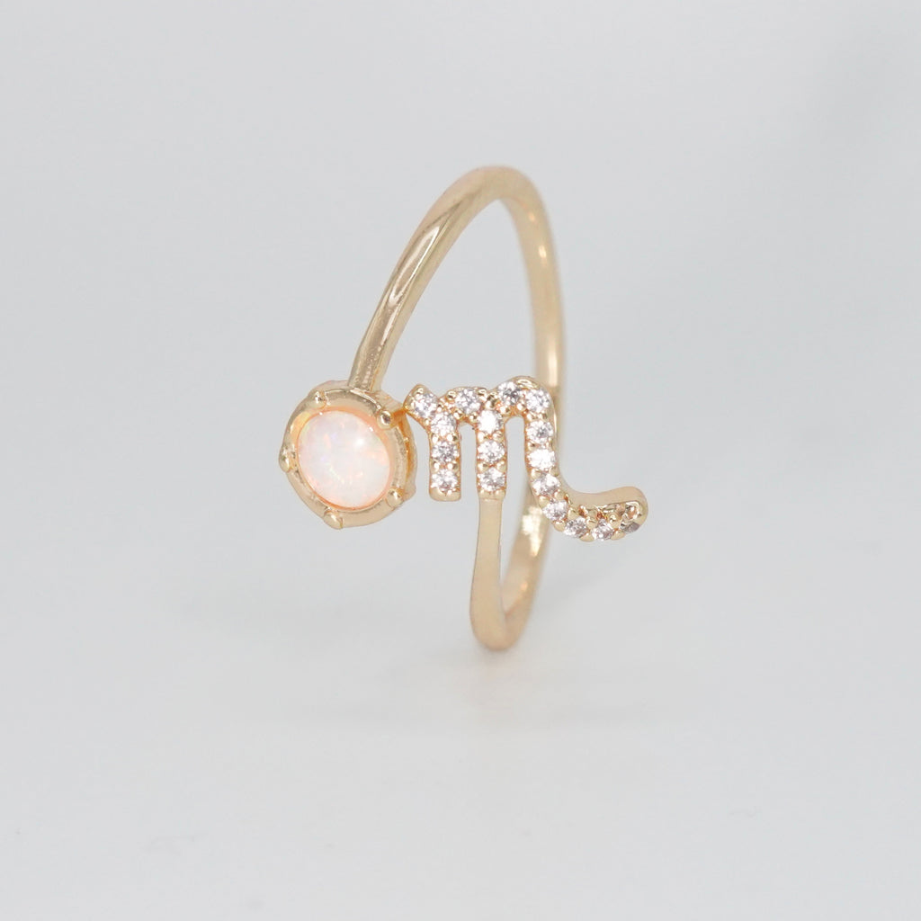 Scorpio Ring: Scorpion symbol with shimmering stones surrounding an opal, epitome of intensity.
