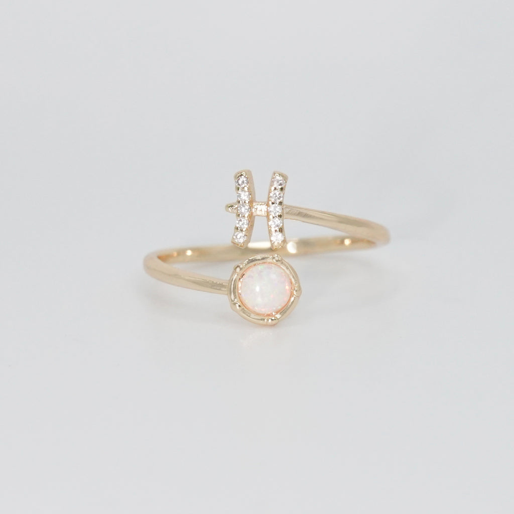 Pisces Ring: Fish symbol with shimmering stones surrounding an opal, epitome of creativity.