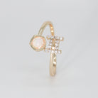 Gemini Ring: Twin symbols with shimmering stones surrounding an opal, symbolizing duality.