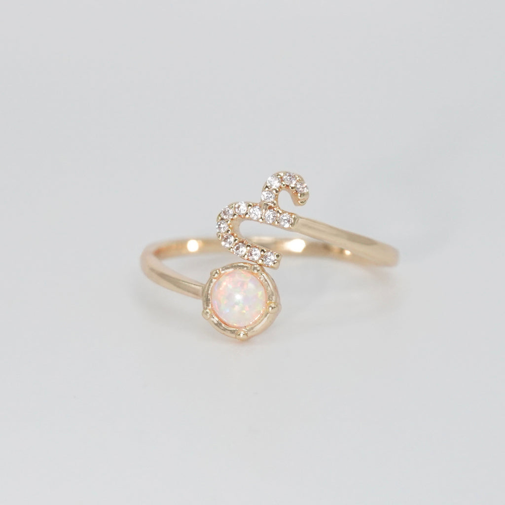 Capricorn Ring: Goat symbol with shimmering stones surrounding an opal, epitome of ambition.
