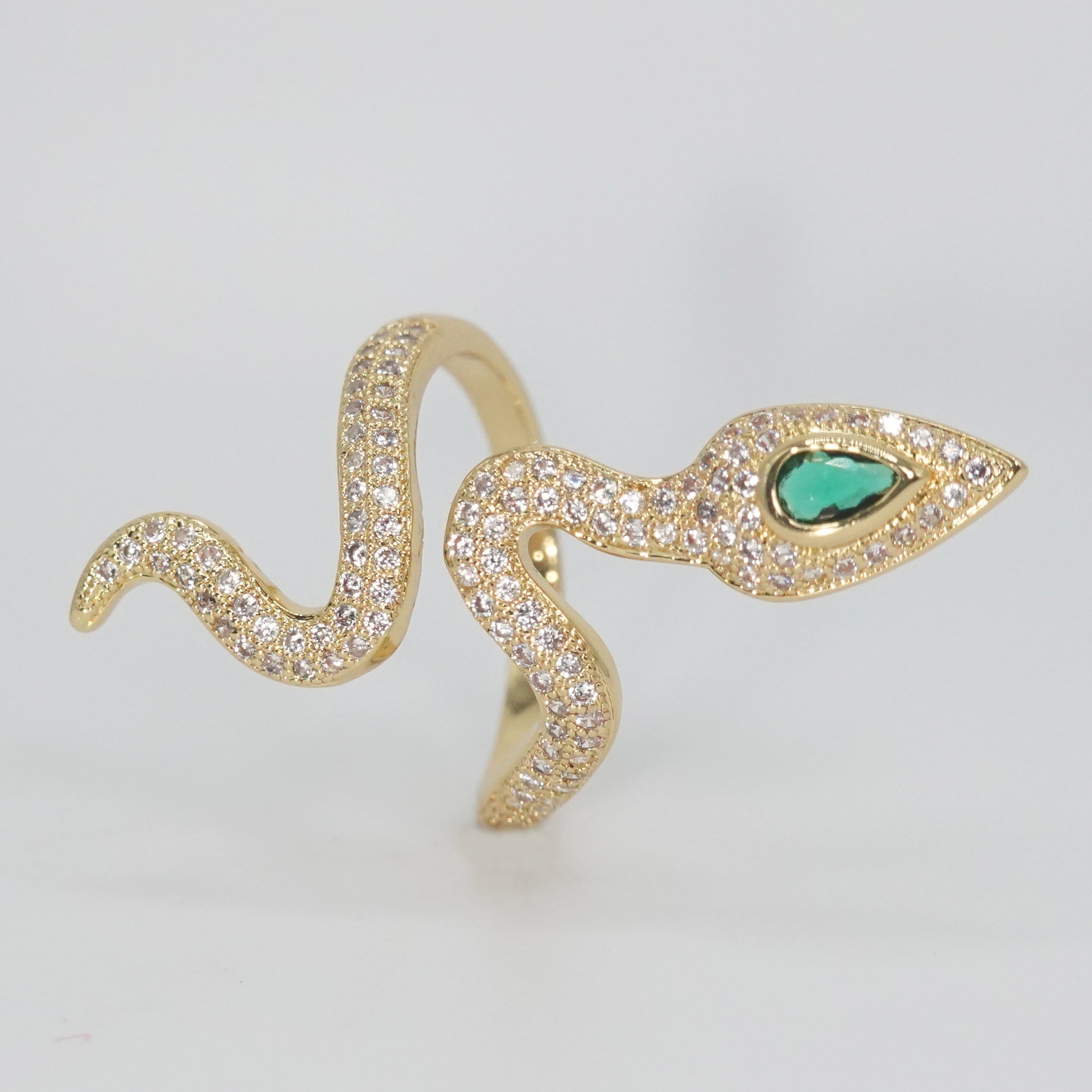A dazzling array of shimmering stones with a captivating green gemstone at its head, epitome of sophistication.