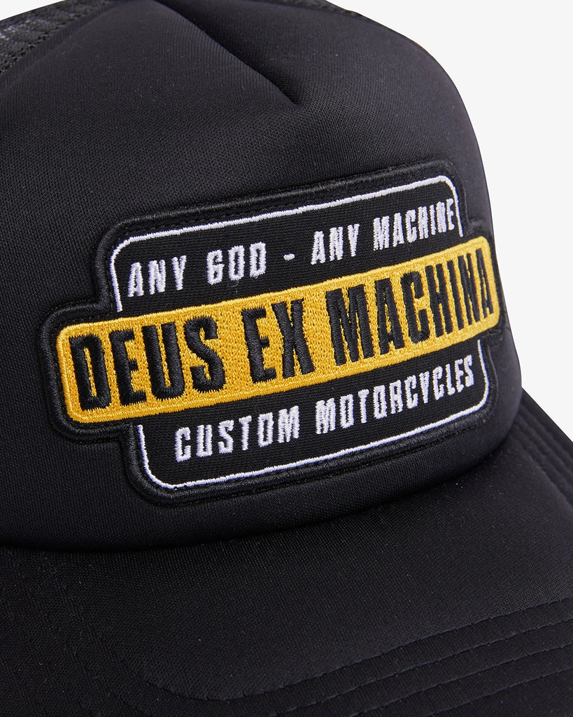 Image of the 'Deus Ex Machina - Grip Tape Trucker' cap, featuring a front embroidered patch, back embroidered art, and a breathable polyester mesh fabric.
