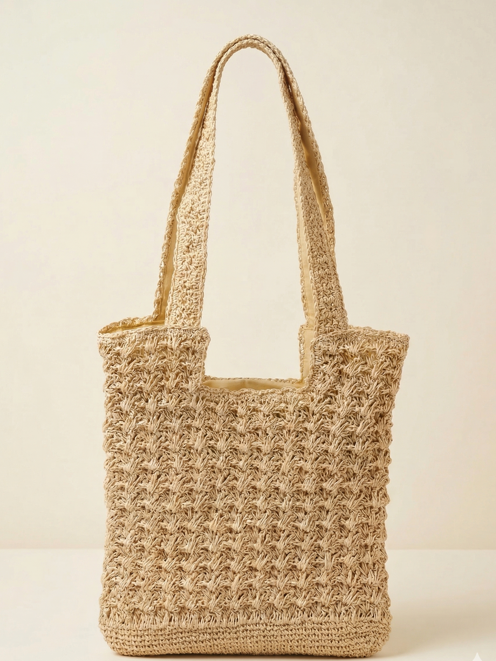 Woven straw tote bag on a light beige background