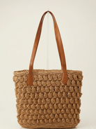 Brown woven tote bag with brown leather straps on a light beige background