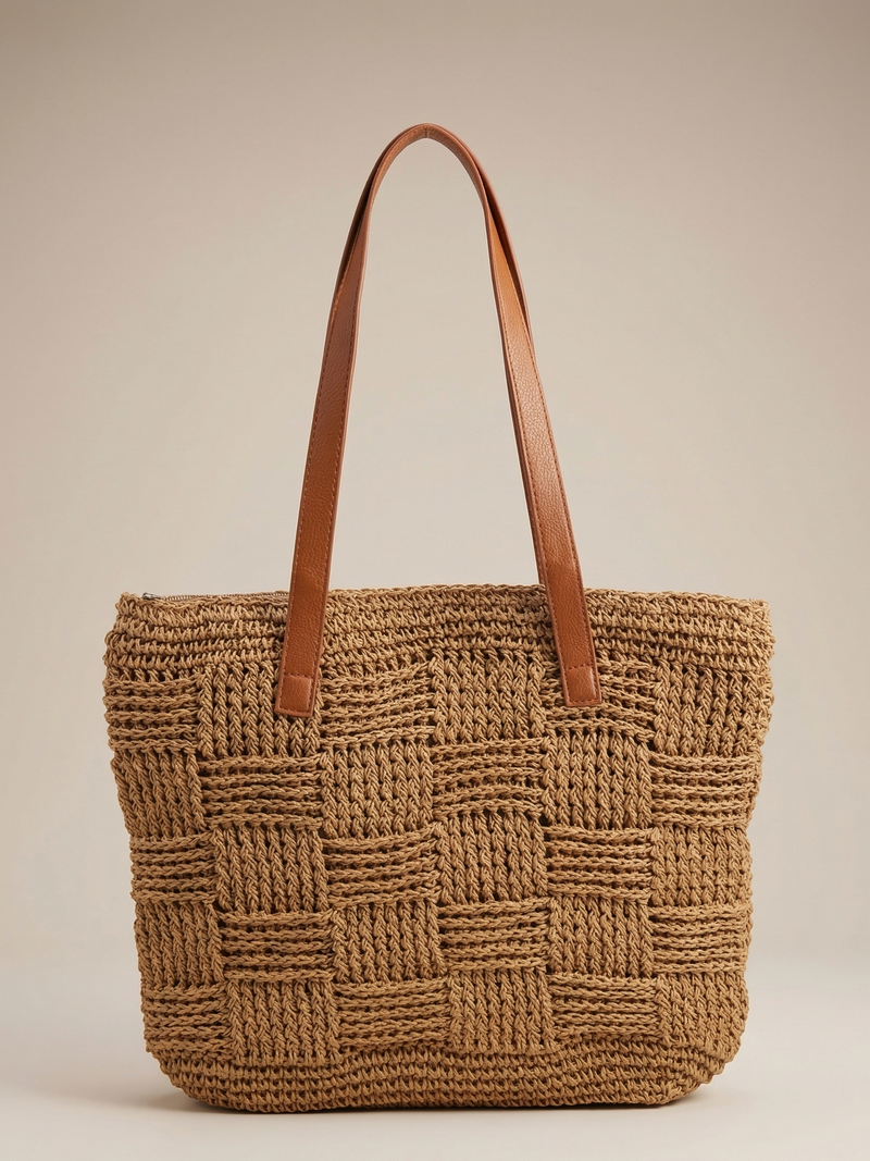 Woven brown bag with leather handles on a beige background