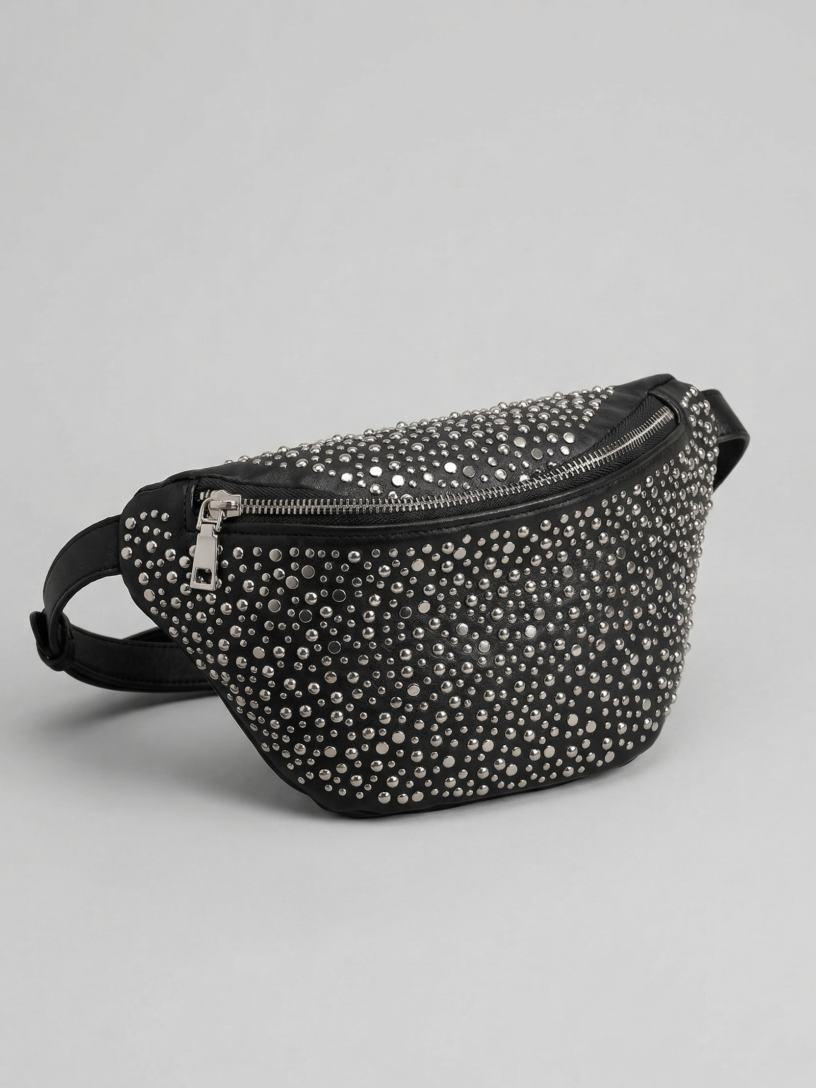 Black studded belt bag on a light gray background