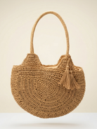 Brown woven handbag with a tassel on a beige background