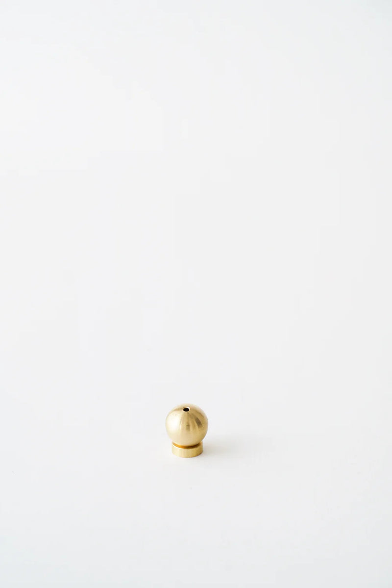 A modern Sphere Incense Holder placed on a minimalist backdrop, ideal for holding incense sticks in a stylish and secure manner.