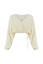 Siena Top displayed on a hanger, showcasing its wide sleeves and the unique V-shaped front drape with a hidden optional closure.