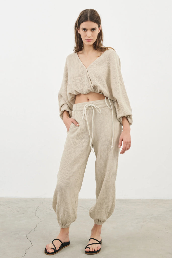 Siena Top displayed on a hanger, showcasing its wide sleeves and the unique V-shaped front drape with a hidden optional closure.