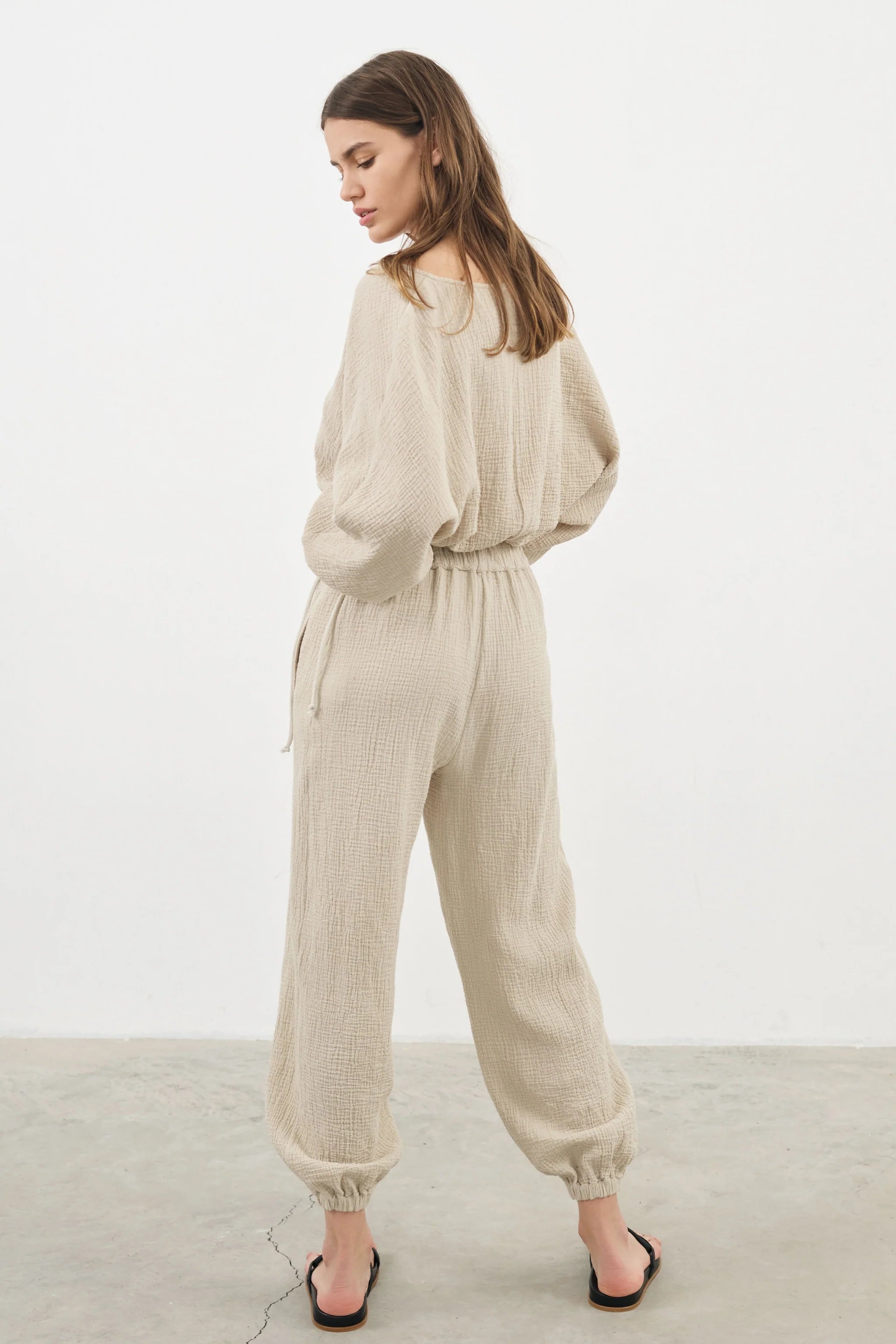 Siena Top displayed on a hanger, showcasing its wide sleeves and the unique V-shaped front drape with a hidden optional closure.