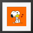 Framed artwork of Snoopy hugging Woodstock with red hearts, set against a bright orange background and framed in black.